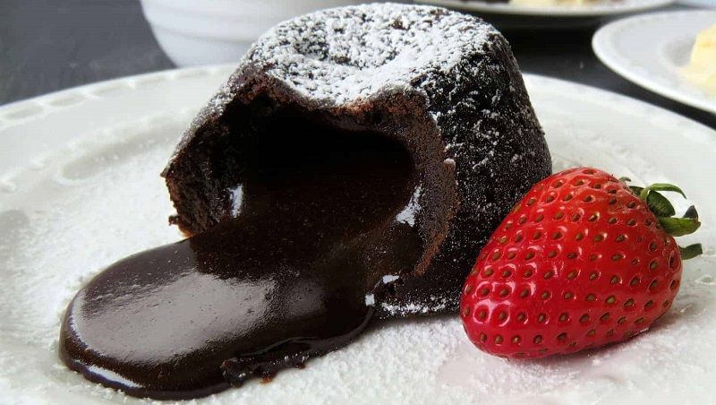 </ "پودینگ شکلاتی تلخ به صورت گرم و توت‌فرنگی در ساختار کیک شکلاتی به کار رفته است "=jpg" alt.کیک-شکلات-تلخ"=img src>